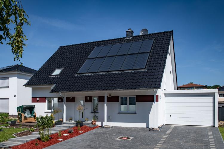 Elegante Fassade, nachhaltige Haustechnik: 12 Solarkollektoren auf der Südseite des Daches sammeln solare Erträge für Heizung und Warmwasserbereitung über das ganze Jahr hinweg. <i>Foto: HELMA Eigenheimbau AG / Claudius Pflug</i><br>