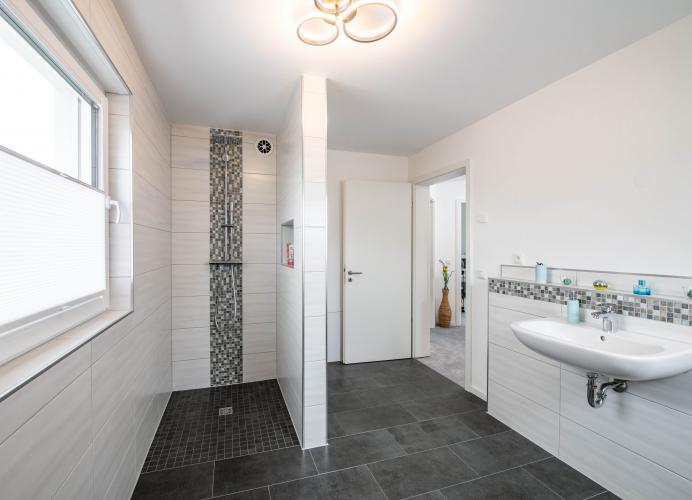 Das Bad mit Walk-in-Dusche überzeugt durch viel Platz und eine hochwertige Ausstattung. Foto: Helma Eigenheimbau AG / Claudius Pflug