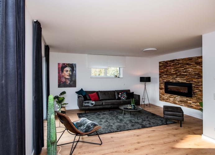 Im Wohnbereich harmoniert das Echtholzpaneel in 3D-Ausbildung mit dem Bodenbelag in Holzoptik. <i>Foto: HELMA Wohnungsbau GmbH / Claudius Pflug</i>