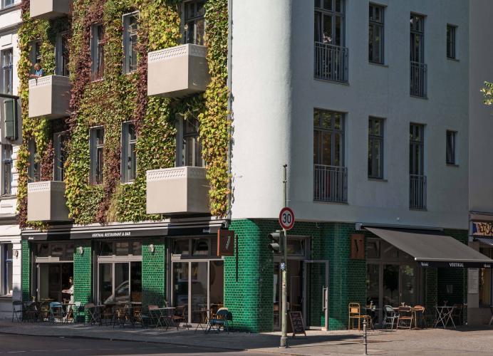 Mit grün glasierten Fliesen setzt die Erdgeschossfassade in Farbe und Materialität einen besonderen Akzent. Besonders auch die begrünte Fassade: Vom ersten Obergeschoss bis zur Traufe ist sie winterhart bepflanzt und sorgt ganzjährig für angenehmes Mikroklima. <i>Foto: Deutsche Poroton / Claudius Pflug</i>