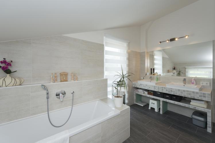 Insel der Entspannung: Im hochwertig ausgestatteten Badezimmer setzt der Doppelwaschtisch mit seinem Fliesenmosaik Akzente. <i>Foto: Roth-Massivhaus / Gerhard Zwickert</i>