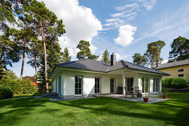 Auf einer Ebene mitten im Grünen wohnen: Der Winkelbungalow Ahlbeck mit seiner geschützten Terrasse gehört zu den beliebtesten Häusern von Roth-Massivhaus. <i>Foto: Roth-Massivhaus / G. Zwickert</i><br>
