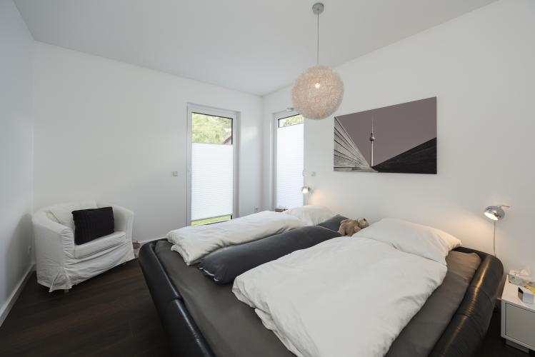 Das Schlafzimmer der Bauherren liegt zwischen Bad und Ankleideraum und bietet damit einen schönen Rückzugsort. <i>Foto: Roth-Massivhaus / Gerhard Zwickert</i>